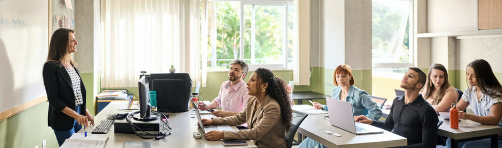 Adult students study in a classroom with female lecturer